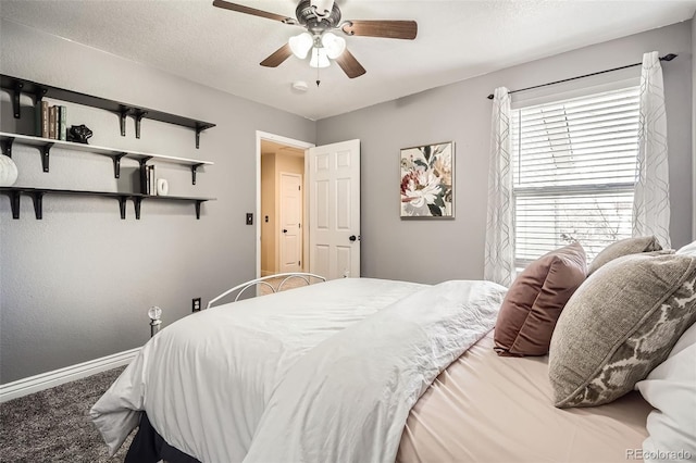 carpeted bedroom featuring ceiling fan, baseboards, and a textured ceiling