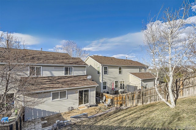 rear view of property featuring a yard and fence