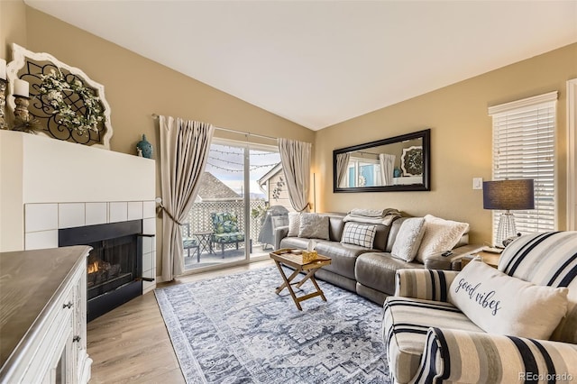8334 Pebble Creek Way Unit 201, Highlands Ranch, CO 80126 - living area with light wood-style floors, vaulted ceiling, and a fireplace