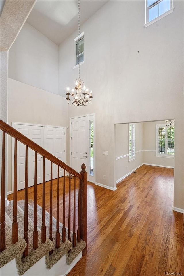 10205 Bluffmont Dr, Lone Tree, CO 80124 - foyer entrance featuring a towering ceiling, a chandelier, wood finished floors, and stairway