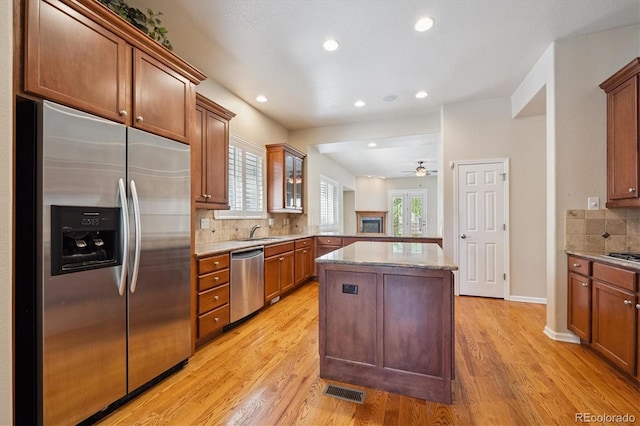 10205 Bluffmont Dr, Lone Tree, CO 80124 - kitchen featuring stainless steel appliances, tasteful backsplash, light wood-style flooring, light stone counters, and recessed lighting