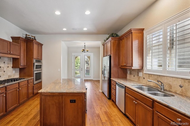 10205 Bluffmont Dr, Lone Tree, CO 80124 - kitchen featuring stainless steel appliances, a kitchen island, light wood-style flooring, brown cabinets, and recessed lighting