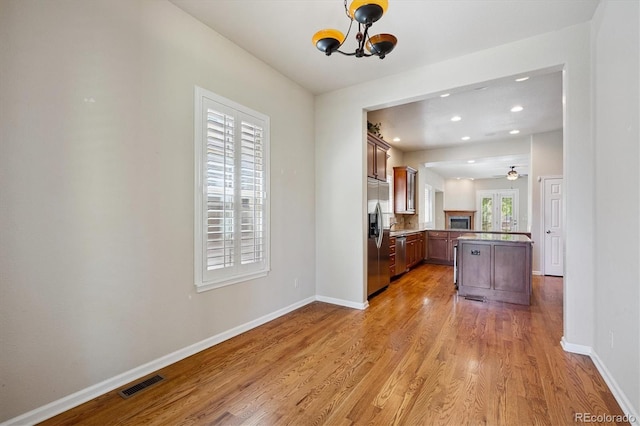 10205 Bluffmont Dr, Lone Tree, CO 80124 - kitchen with stainless steel appliances, light wood finished floors, a chandelier, a peninsula, and recessed lighting
