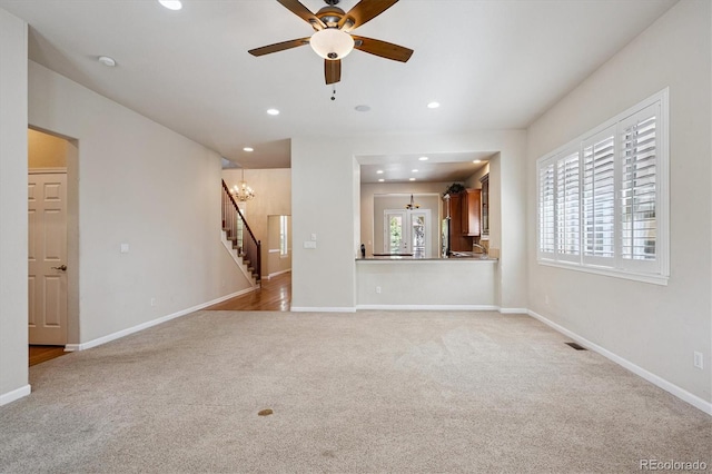 10205 Bluffmont Dr, Lone Tree, CO 80124 - unfurnished living room with light carpet, stairway, a ceiling fan, and recessed lighting