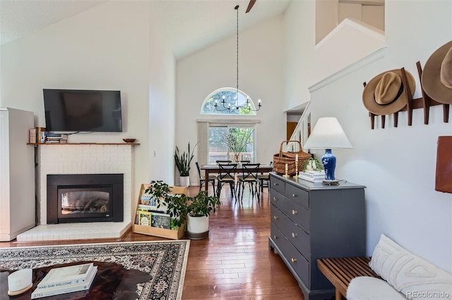 728 Poppywood Pl, Highlands Ranch, CO 80126 - living room with a chandelier, hardwood / wood-style floors, high vaulted ceiling, and a brick fireplace