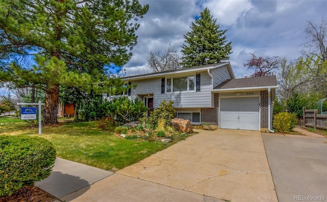 split foyer home with concrete driveway, a front lawn, fence, a garage, and brick siding