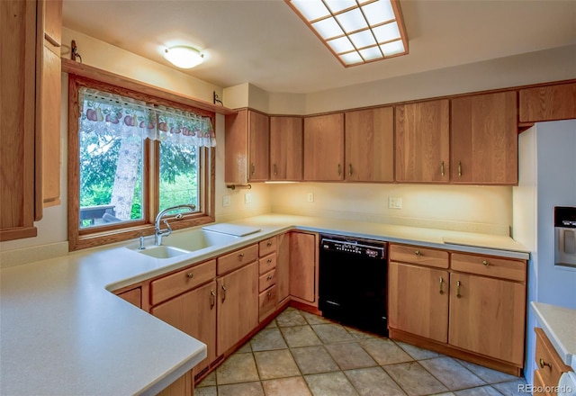 kitchen with black dishwasher, light countertops, and a sink