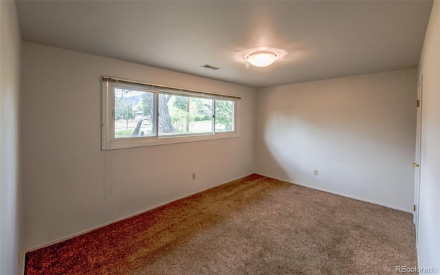 carpeted empty room featuring visible vents