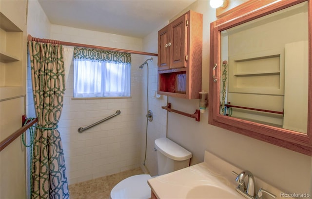 bathroom featuring vanity, toilet, and tiled shower