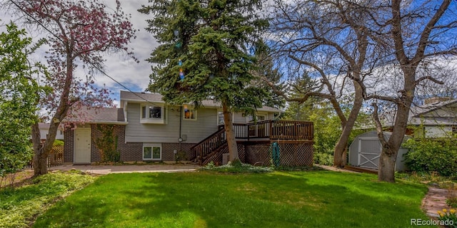 rear view of property featuring a storage shed, brick siding, a lawn, stairs, and a deck