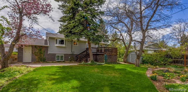 view of yard featuring stairway, fence, an outdoor structure, a storage unit, and a deck