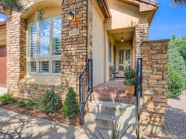 5092 S Allison Way, Littleton, CO 80123 - property entrance featuring stucco siding, stone siding, and covered porch