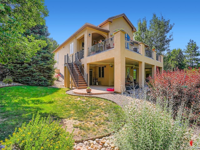 5092 S Allison Way, Littleton, CO 80123 - back of property with stucco siding, stairway, a patio area, a lawn, and a balcony