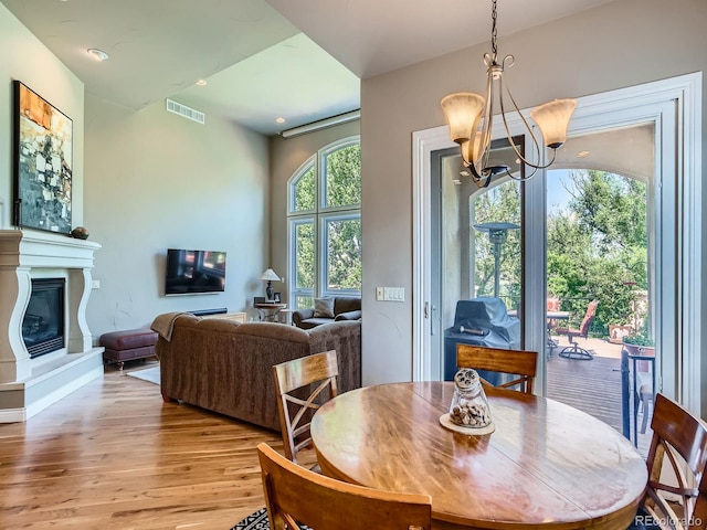 5092 S Allison Way, Littleton, CO 80123 - dining space with a chandelier, light wood finished floors, and a glass covered fireplace