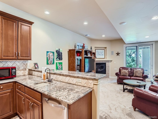 5092 S Allison Way, Littleton, CO 80123 - kitchen featuring open floor plan, a fireplace, a peninsula, light stone countertops, and brown cabinets
