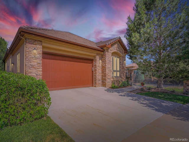 5092 S Allison Way, Littleton, CO 80123 - view of front of home featuring stone siding, an attached garage, concrete driveway, and a tile roof