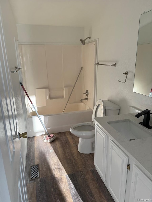 full bathroom with hardwood / wood-style flooring, vanity, shower / washtub combination, and toilet