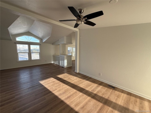 unfurnished living room with vaulted ceiling, a healthy amount of sunlight, and dark hardwood / wood-style floors