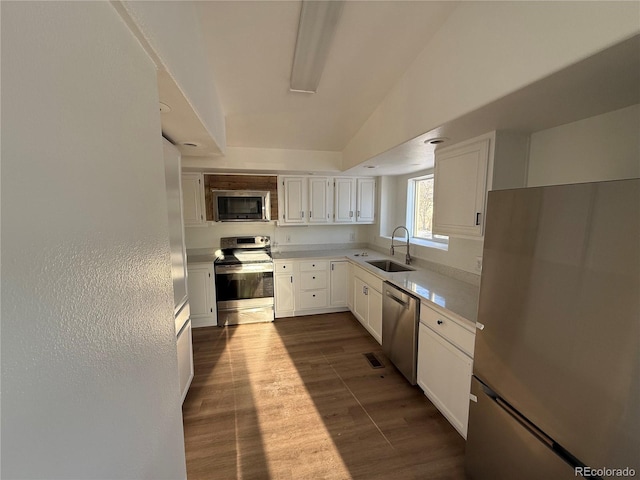 kitchen with white cabinetry, appliances with stainless steel finishes, sink, and wood-type flooring