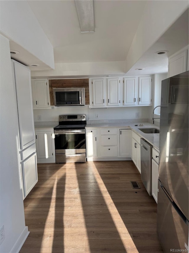 kitchen with dark hardwood / wood-style floors, white cabinets, and appliances with stainless steel finishes