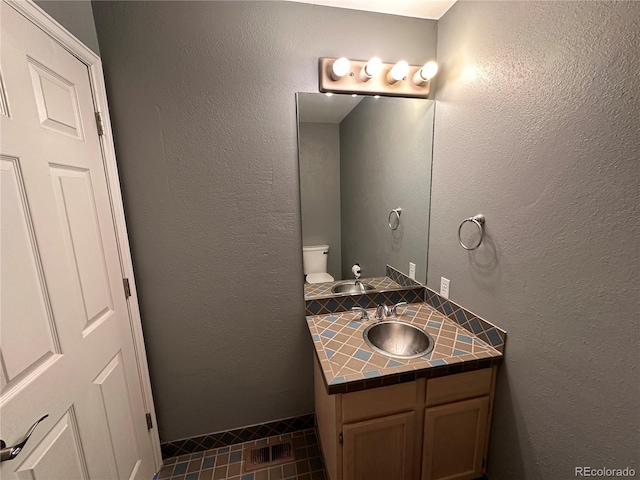 bathroom featuring vanity, toilet, and tile patterned flooring