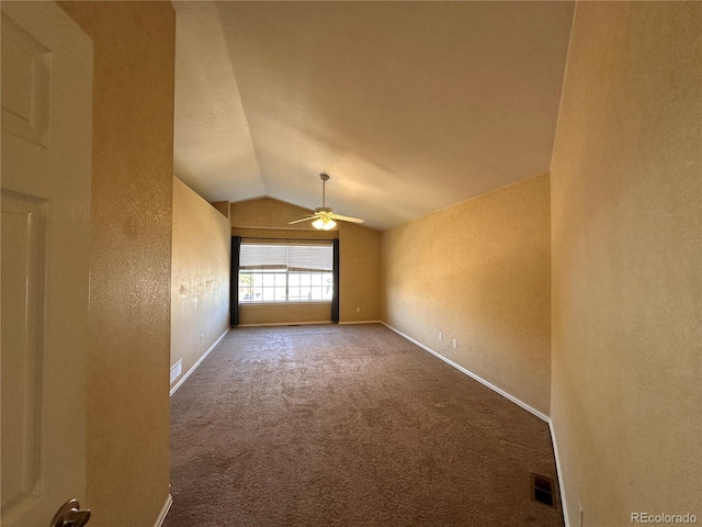 unfurnished room featuring ceiling fan, carpet flooring, and vaulted ceiling