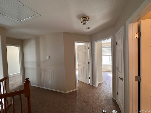 hallway featuring dark carpet