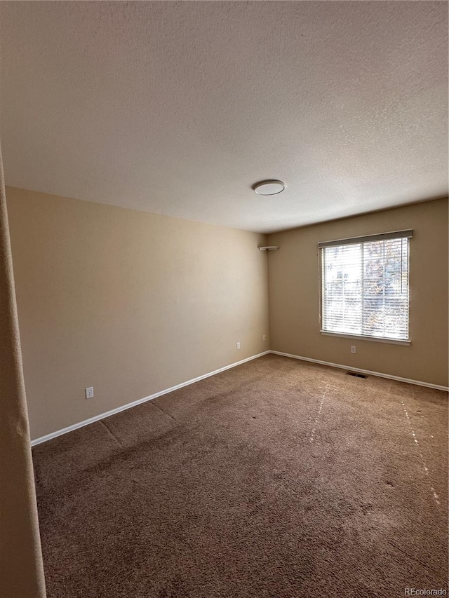 carpeted spare room with a textured ceiling