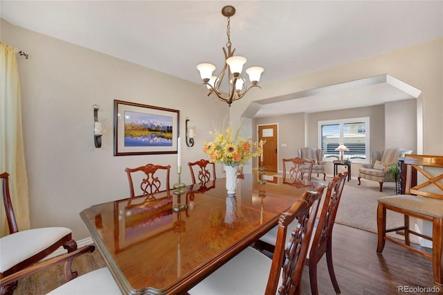 dining room with wood finished floors, a chandelier, and baseboards