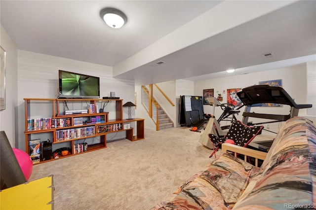 carpeted living area with stairs
