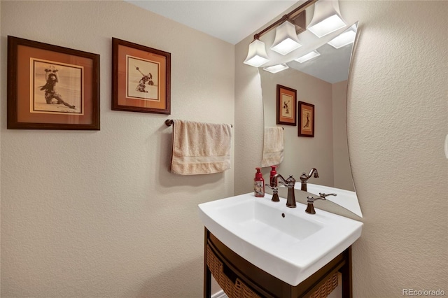 bathroom with vanity and a textured wall