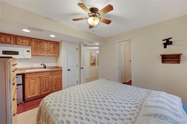 bedroom featuring a sink, freestanding refrigerator, recessed lighting, and baseboards