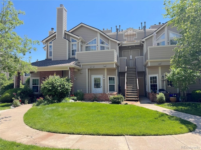 4760 S Wadsworth Blvd Unit F105, Littleton, CO 80123 - view of property with stairway, a front lawn, a chimney, and brick siding