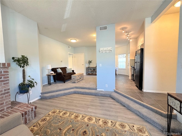 4760 S Wadsworth Blvd Unit F105, Littleton, CO 80123 - living area with baseboards, dark wood-style flooring, and a textured ceiling