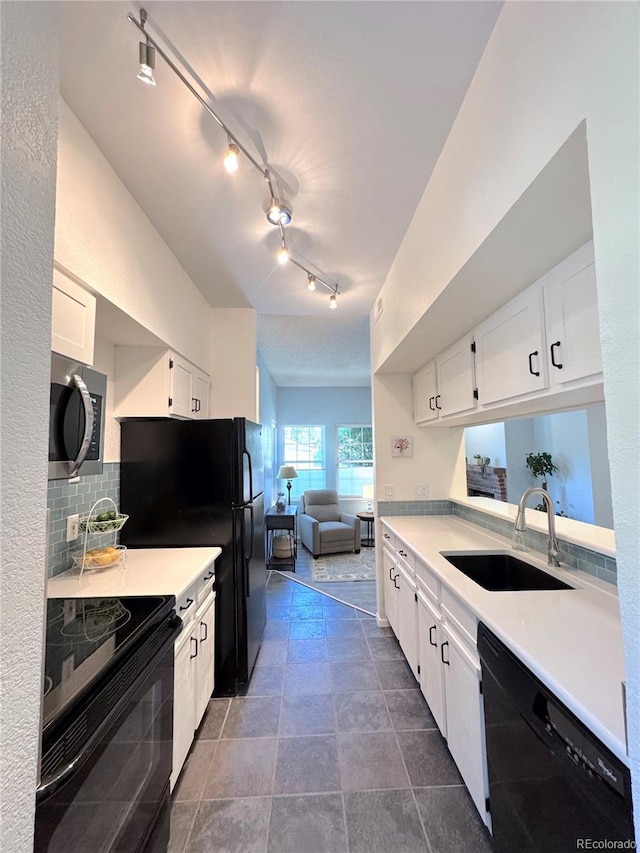 4760 S Wadsworth Blvd Unit F105, Littleton, CO 80123 - kitchen with black appliances, a sink, white cabinets, light countertops, and decorative backsplash