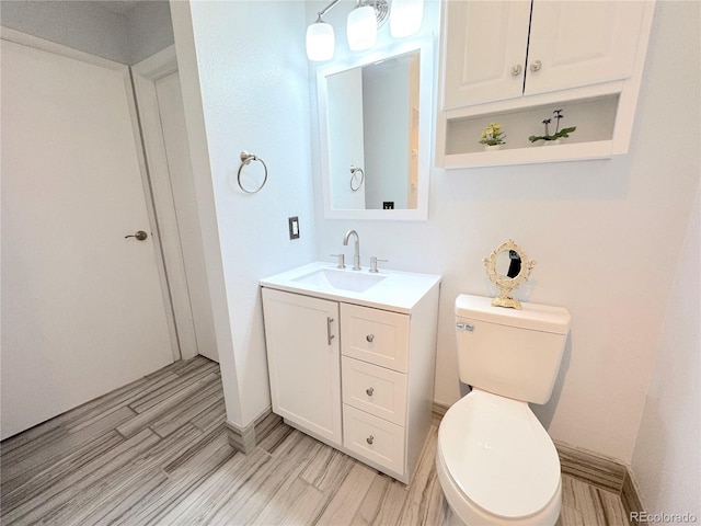 4760 S Wadsworth Blvd Unit F105, Littleton, CO 80123 - half bathroom with vanity, toilet, baseboards, and wood finished floors