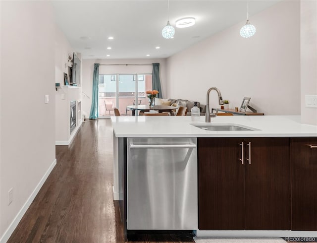 kitchen featuring dishwasher, open floor plan, decorative light fixtures, light countertops, and a sink