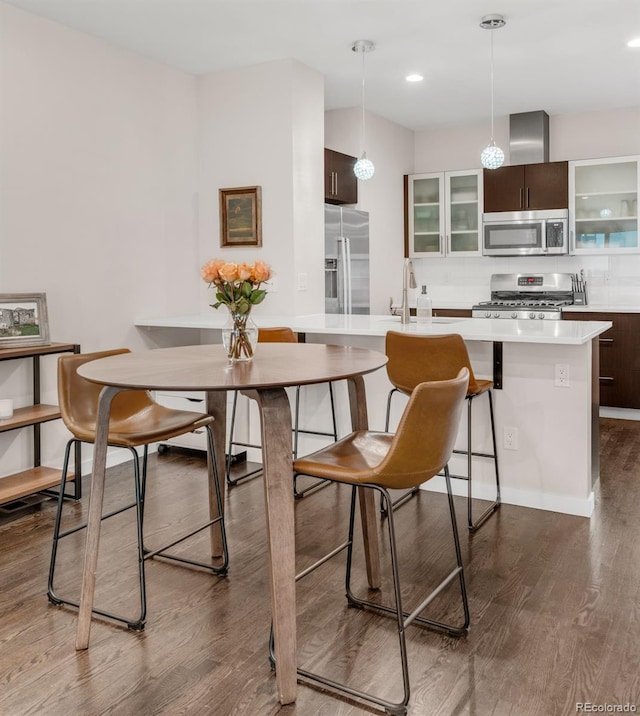 dining space with dark wood-style floors, baseboards, and recessed lighting