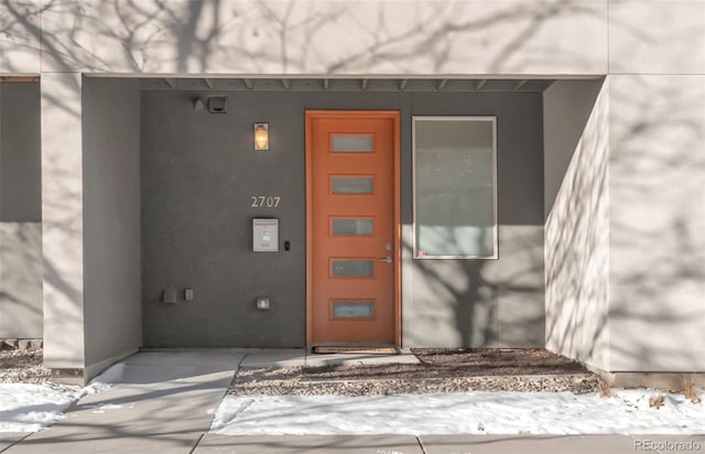 entrance to property featuring stucco siding