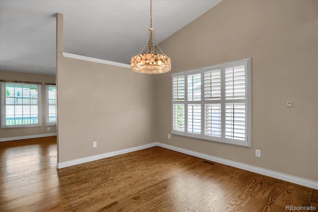 8951 Greenwich St, Highlands Ranch, CO 80130 - unfurnished room with healthy amount of natural light, wood finished floors, baseboards, and vaulted ceiling