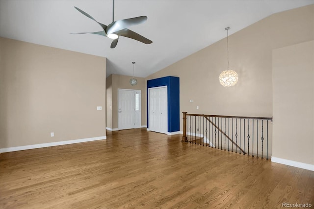 8951 Greenwich St, Highlands Ranch, CO 80130 - empty room featuring ceiling fan, wood finished floors, baseboards, a chandelier, and high vaulted ceiling