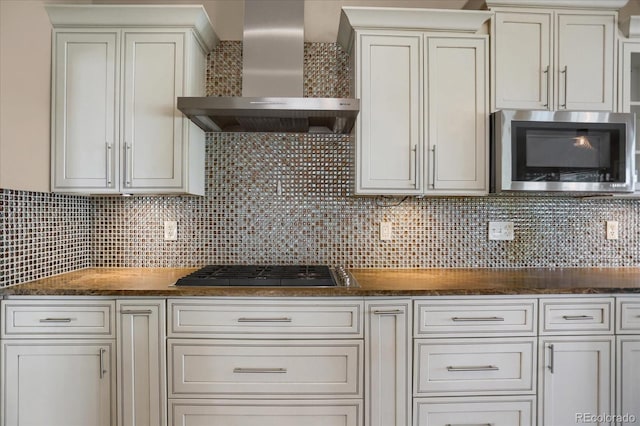 8951 Greenwich St, Highlands Ranch, CO 80130 - kitchen with stainless steel microwave, wall chimney exhaust hood, gas cooktop, and tasteful backsplash