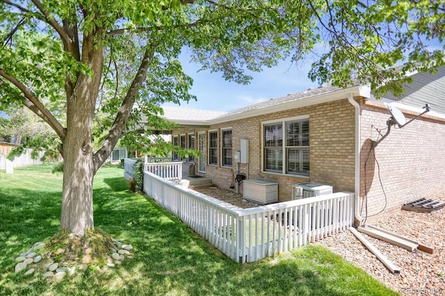 8951 Greenwich St, Highlands Ranch, CO 80130 - rear view of property with brick siding, a yard, a deck, and cooling unit