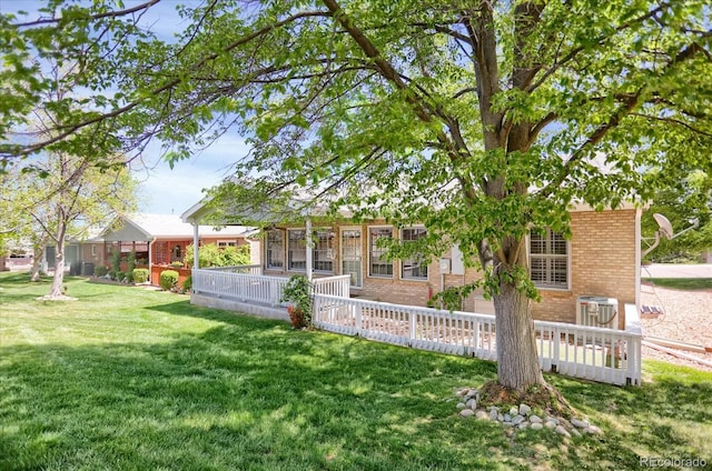 8951 Greenwich St, Highlands Ranch, CO 80130 - back of property featuring brick siding, a yard, and central AC