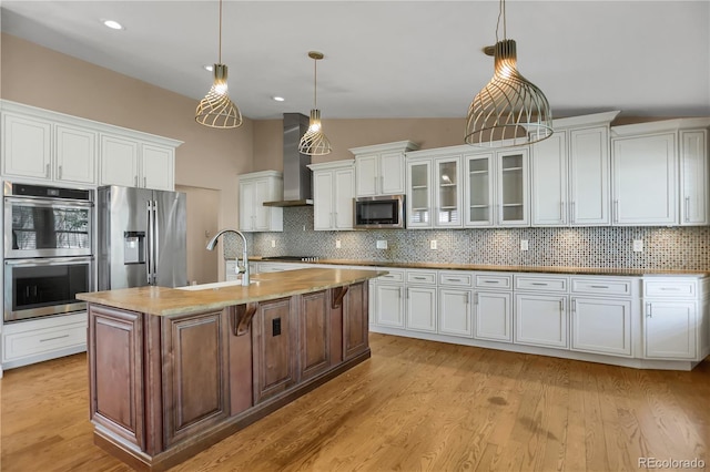 8951 Greenwich St, Highlands Ranch, CO 80130 - kitchen with appliances with stainless steel finishes, wall chimney range hood, white cabinetry, decorative backsplash, and a sink
