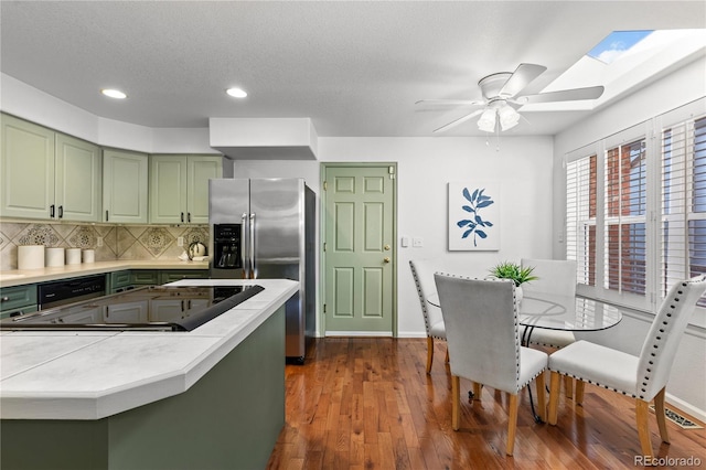 9491 Southern Hills Cir, Lone Tree, CO 80124 - kitchen featuring green cabinetry, recessed lighting, stainless steel fridge with ice dispenser, light countertops, and backsplash