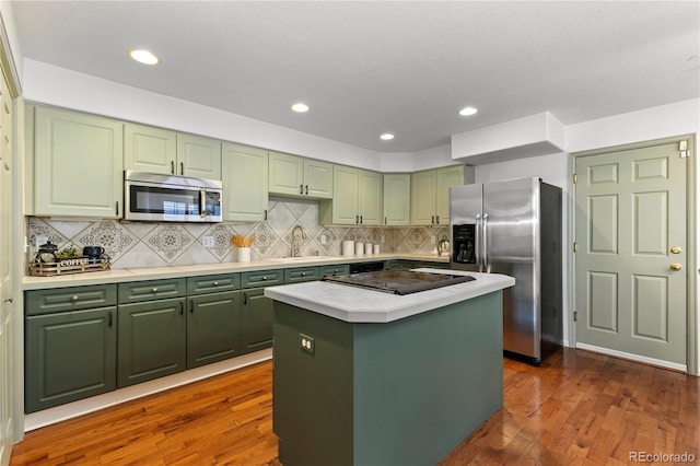 9491 Southern Hills Cir, Lone Tree, CO 80124 - kitchen with green cabinets, appliances with stainless steel finishes, light countertops, dark wood-type flooring, and recessed lighting
