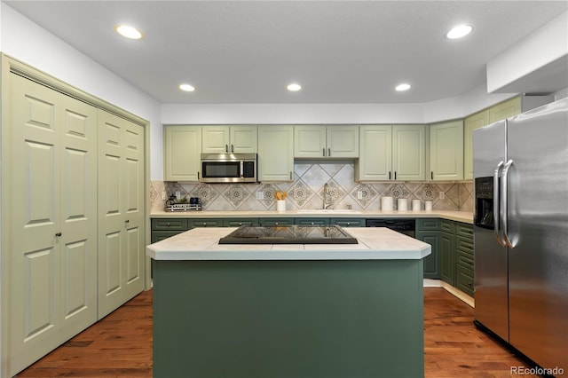 9491 Southern Hills Cir, Lone Tree, CO 80124 - kitchen with green cabinets, appliances with stainless steel finishes, light countertops, dark wood-style flooring, and recessed lighting