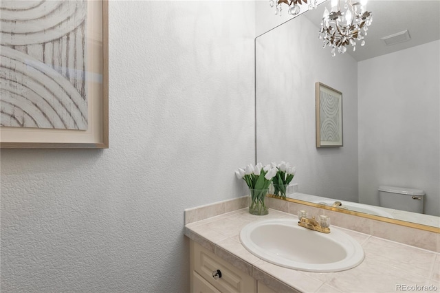 9491 Southern Hills Cir, Lone Tree, CO 80124 - half bath featuring vanity, a chandelier, and a textured wall