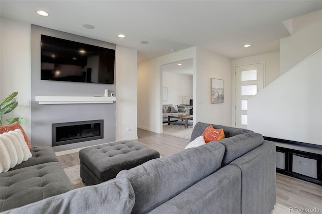 10906 Touchstone Loop, Parker, CO 80134 - living room with light wood-style flooring, recessed lighting, a glass covered fireplace, and stairway